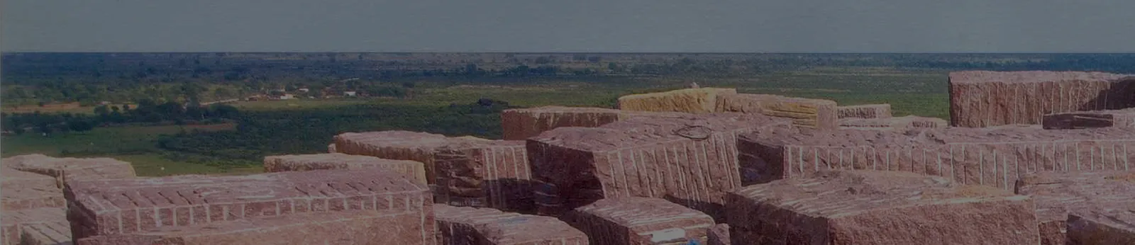 Rows of red granite blocks in a stockyard